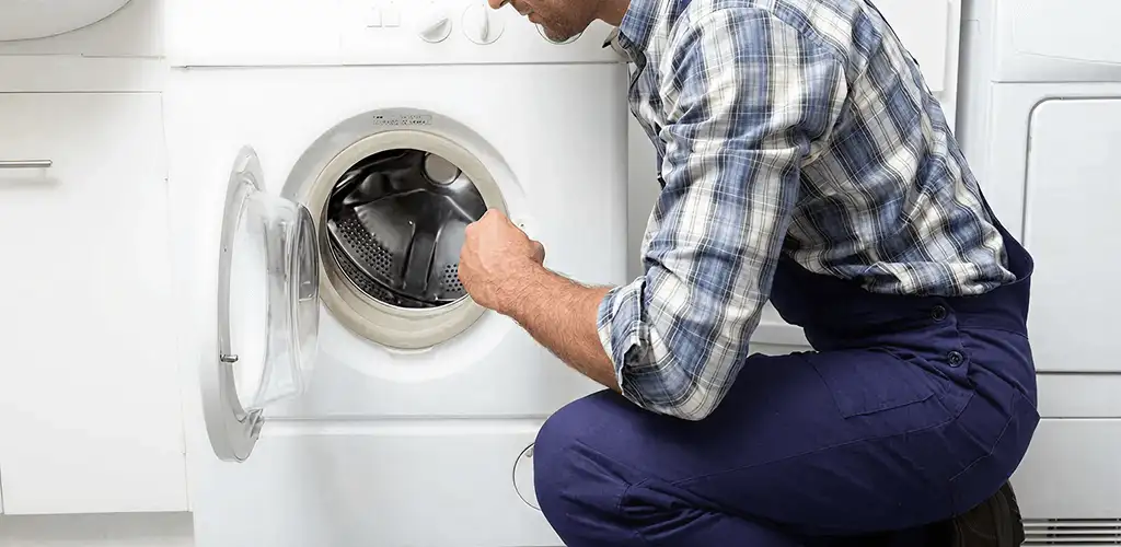 Handyman inspecting a dryer drum and internal parts for repair in Pembroke Pines, FL