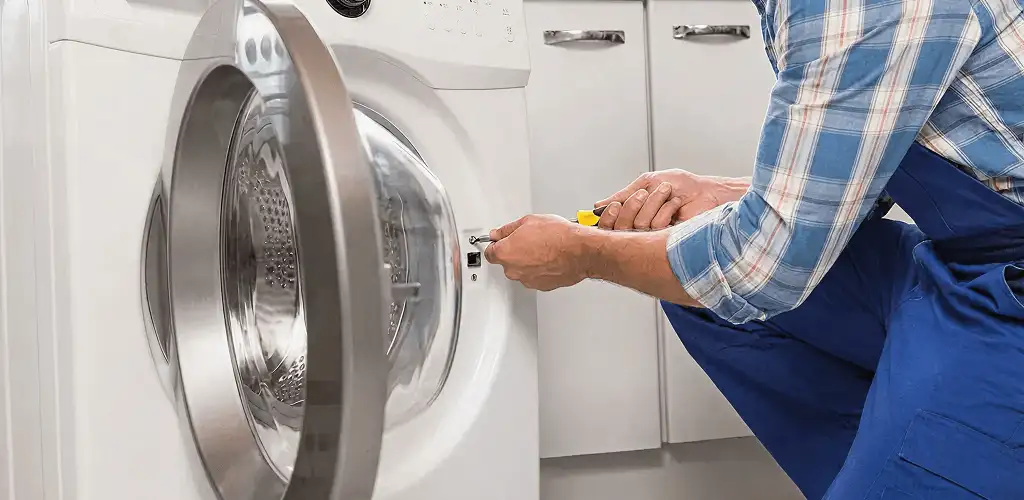 Handyman repairing a clothes dryer and checking electrical connections in Pembroke Pines, FL