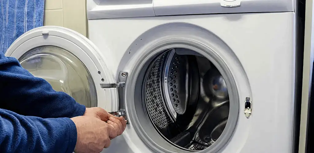 Washing machine repair handyman checking a front-load washer door and latch in Pembroke Pines, FL