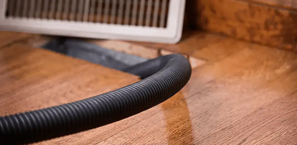 Air duct cleaning hose inserted into a floor vent for ductwork cleaning in Pembroke Pines, FL
